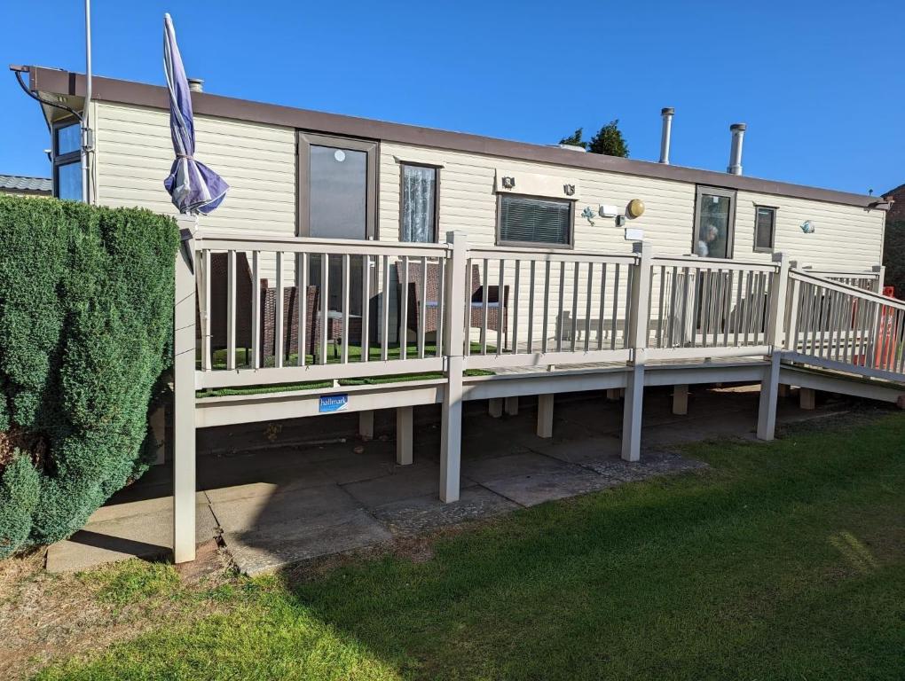 a mobile home with a deck and a fence at Superb Caravan With Decking Close To Hunstanton Beach In Norfolk Ref 23060s in Hunstanton