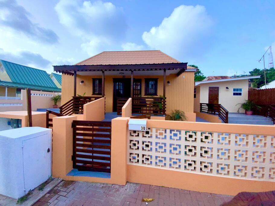 a house with a fence in front of it at Cheerful 2-bedroom home with patio near city center in Willemstad