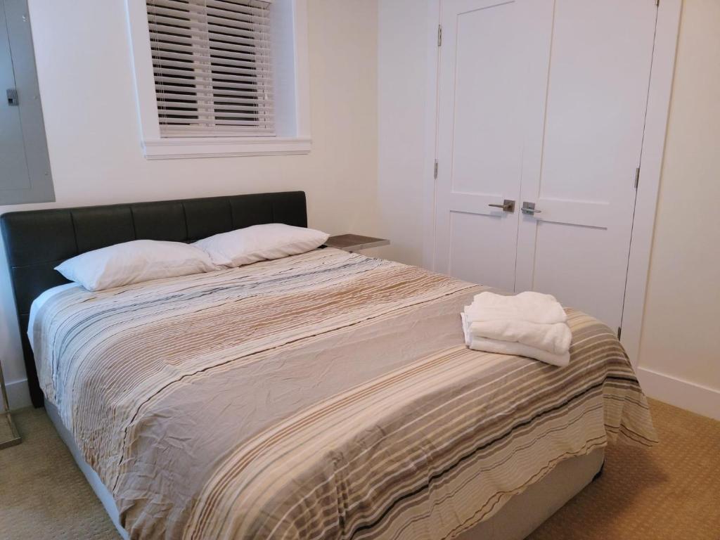 een slaapkamer met een bed met 2 kussens erop bij Peaceful Private Room in Surrey