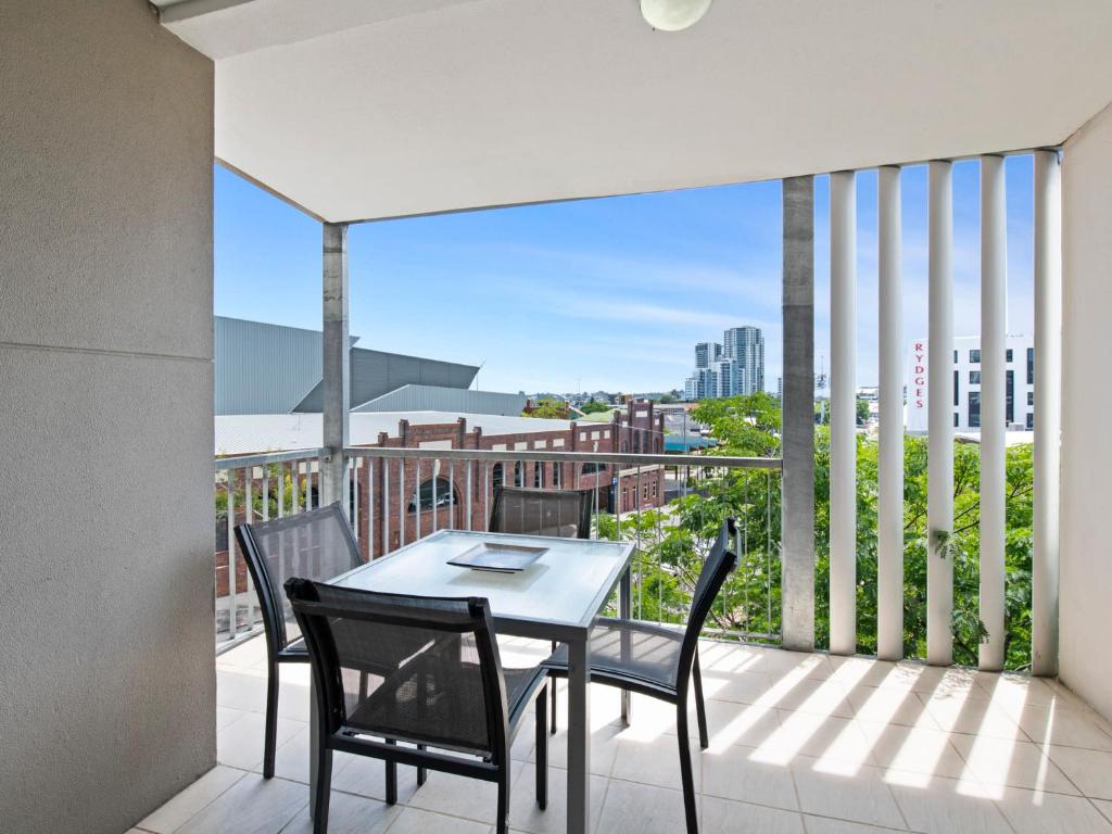 a patio with a table and chairs on a balcony at Artsy Destination Compact & Cosy 2 BR Apart at Valley in Brisbane