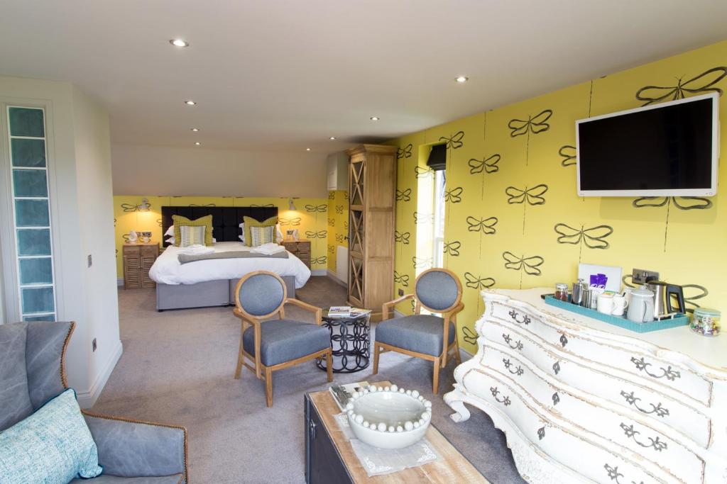 a bedroom with a bed and a tv on a wall at No33 THORNHAM BOUTIQUE SUITES in Thornham