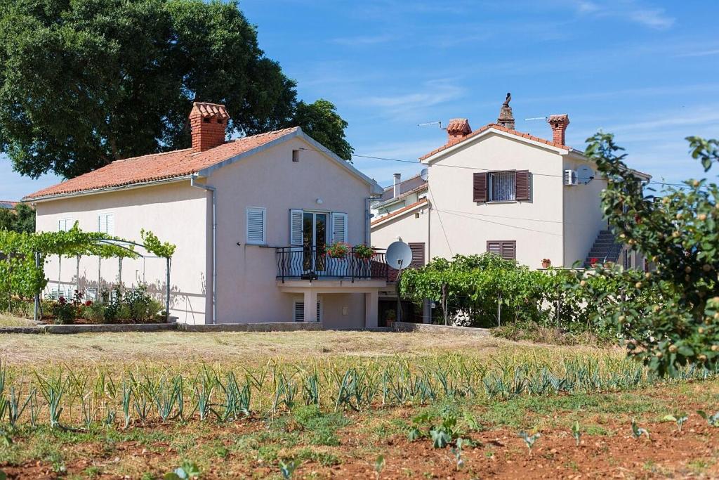 a large white house with a large yard at Apartment Ivy in Malinska