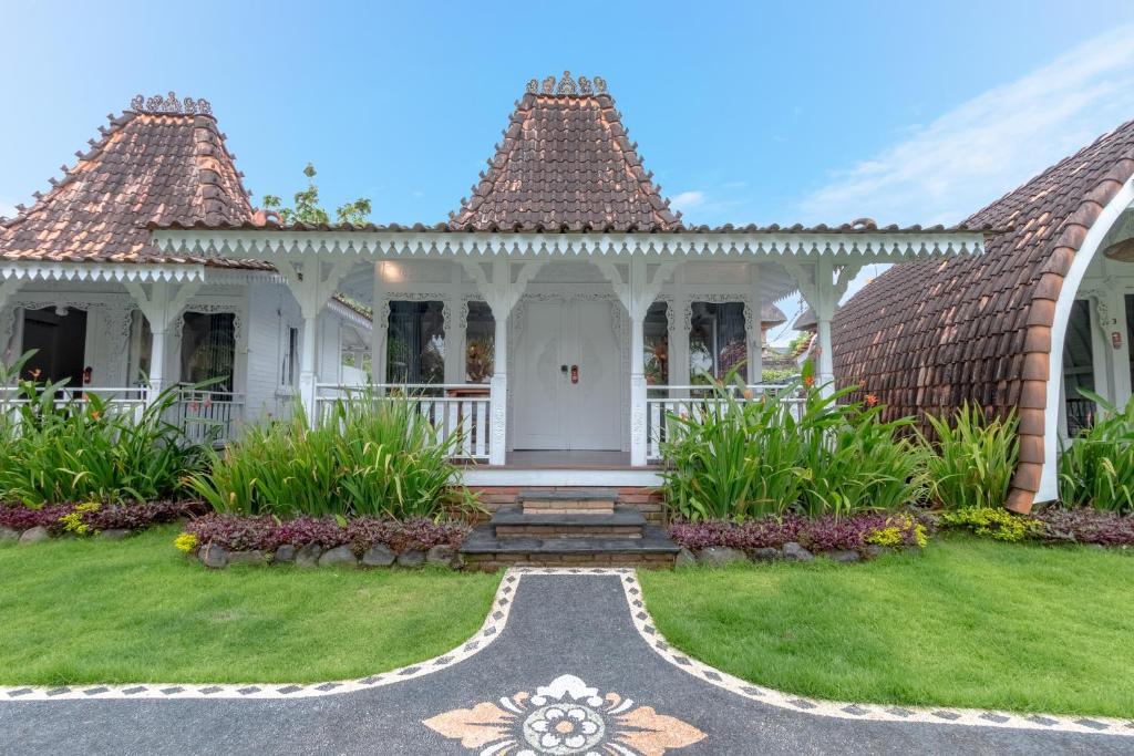 a white house with a pathway leading to the front yard at Elysium Bingin in Uluwatu