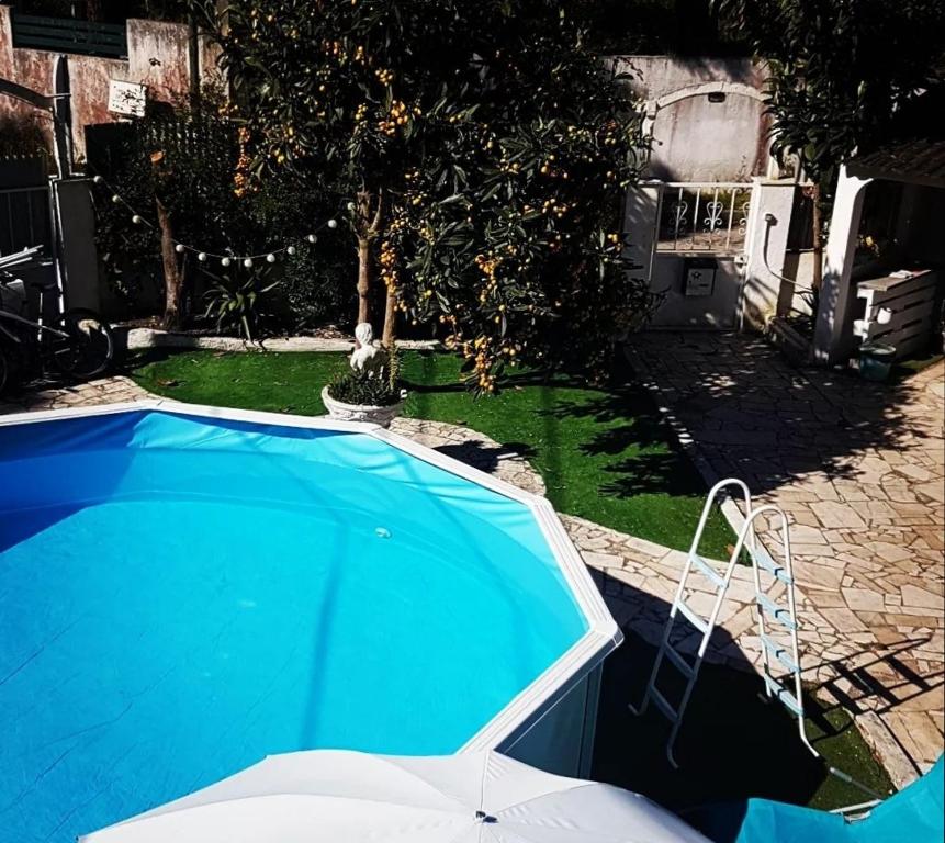 una piscina azul en un patio junto a una casa en H2A en Aroeira