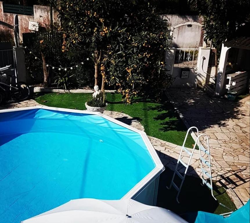 a blue swimming pool in a yard next to a house at H2A in Aroeira