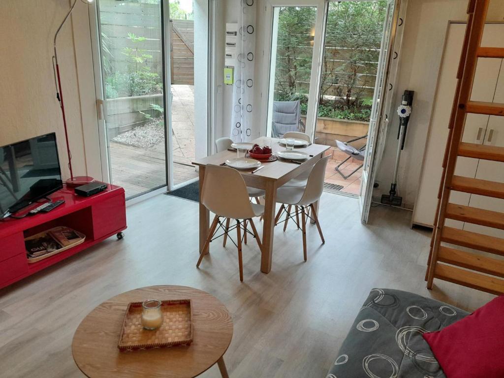 a living room with a table and chairs and a tv at Appartement T1 bis tout confort, proche plages et commerces, Capbreton - FR-1-239-954 in Capbreton