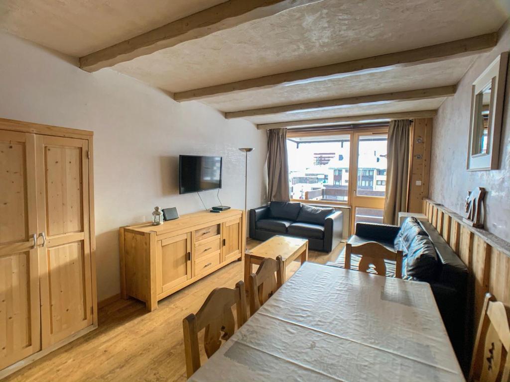 - un salon avec une table, un canapé et une télévision dans l'établissement Appartement rénové 8p à Tignes · Proche pistes et commerces · Balcon · Sud · Animaux acceptés - FR-1-502-508, à Tignes