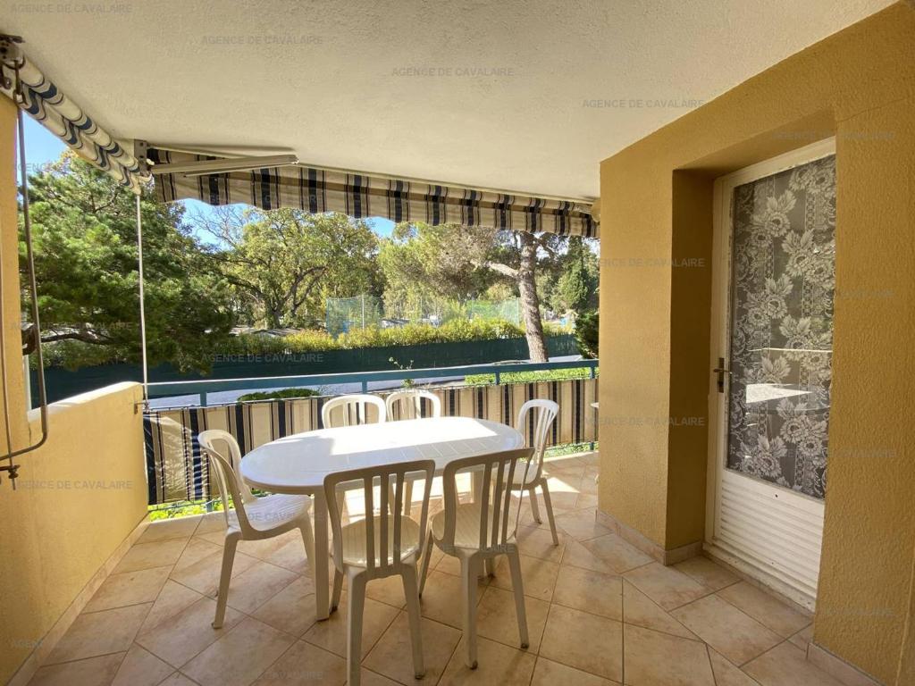 un patio avec une table et des chaises sur un balcon dans l'établissement Appartement T3 - Proche commerces, port et plages - Résidence sécurisée avec parking - FR-1-100-304, à Cavalaire-sur-Mer