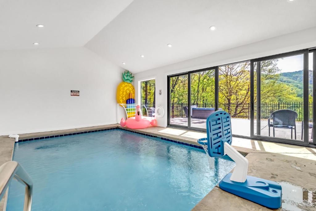 セバービルにあるAlpine Splash - Luxury - Private indoor pool - sleeps 12の大きなスイミングプール(椅子、窓付)