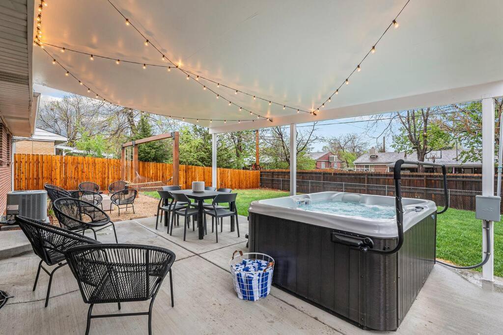 un patio con vasca idromassaggio, tavolo e sedie. di Mile Hi: Amenities Galore a Denver