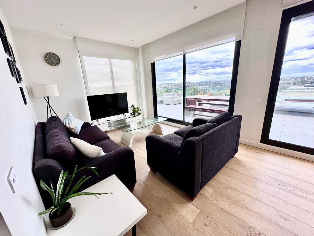 Maribyrnongにある2 Bed 2 Bathroom Penthouse With Amazing Balcony & City Views - Across From Highpointのリビングルーム(ソファ2台、テレビ付)