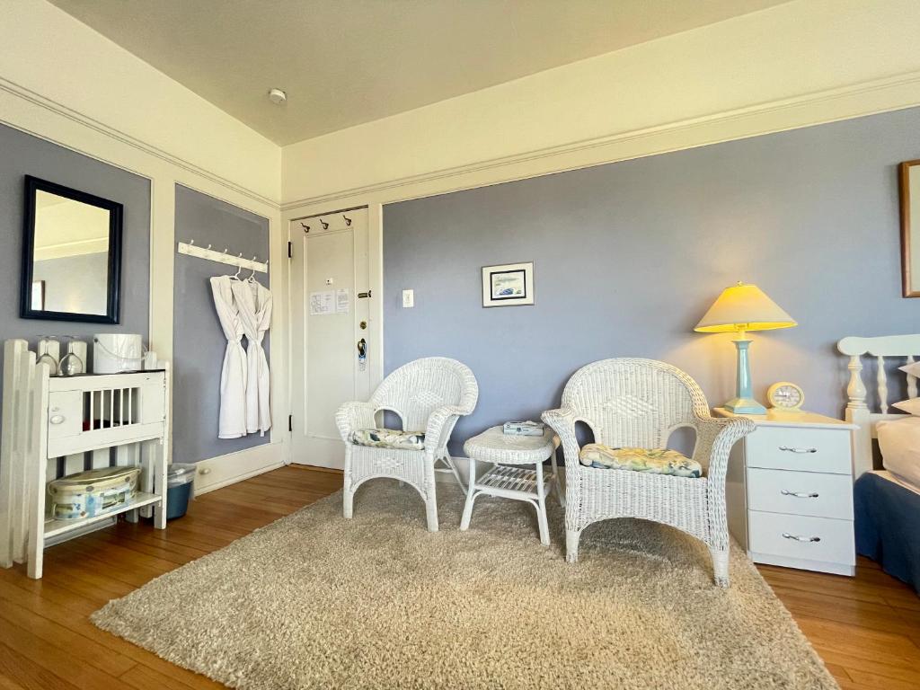 a room with three chairs and a crib and a bedroom at White Rose Inns & Motel in Wisconsin Dells