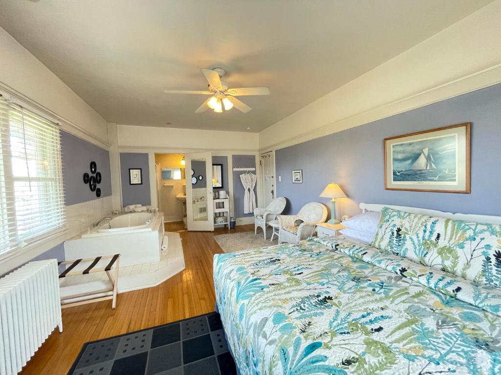 a bedroom with a bed and a bathroom with a tub at White Rose Inns & Motel in Wisconsin Dells