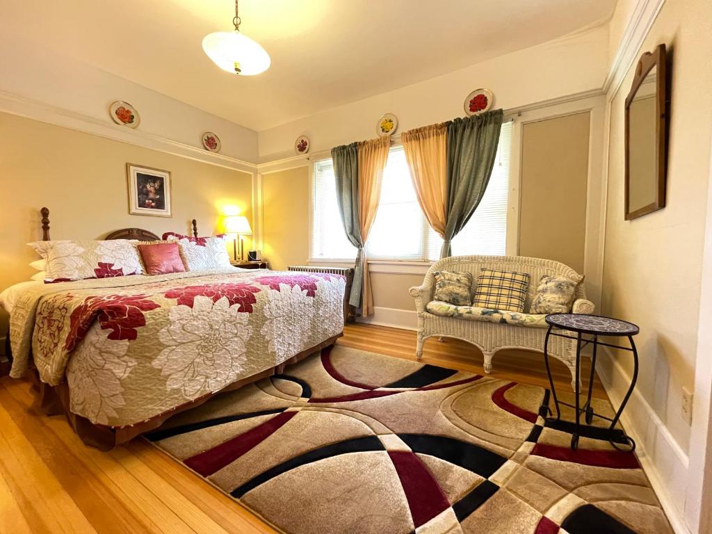 a bedroom with a bed and a chair and a rug at White Rose Inns & Motel in Wisconsin Dells