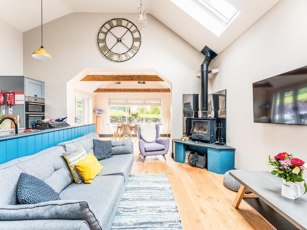 a living room with a couch and a clock on the wall at Stabl in Cross Inn