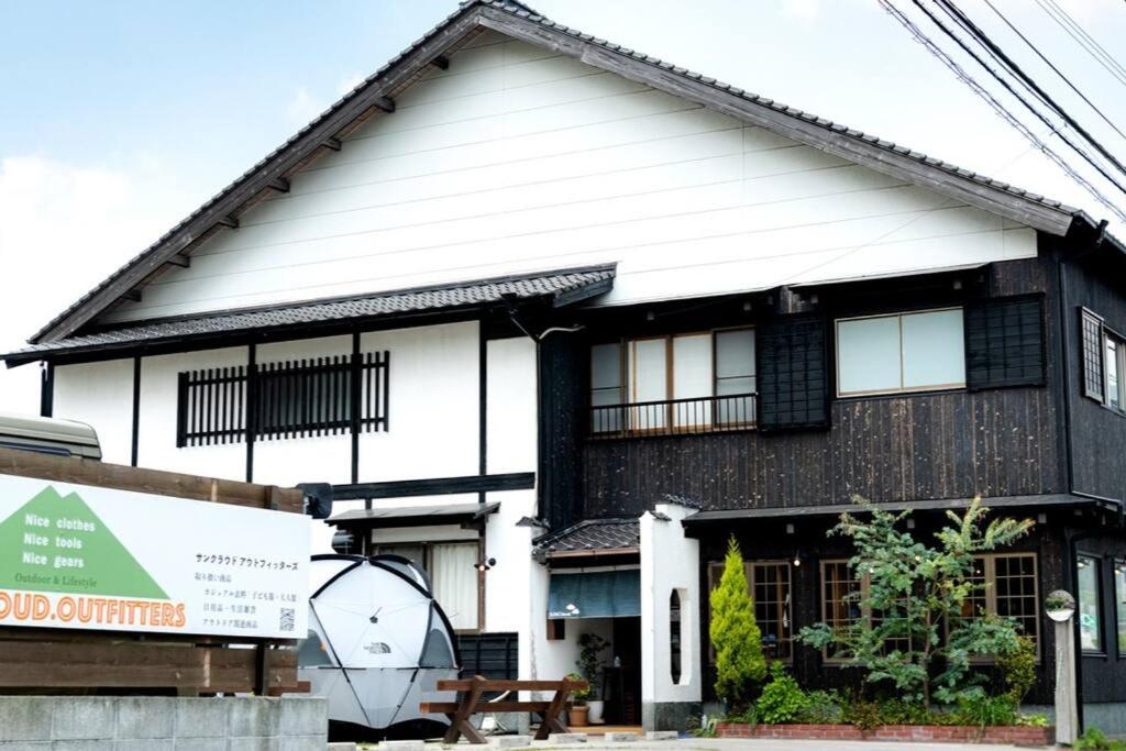 un edificio bianco e nero con un tavolo davanti di 【湯布院の山小屋】サンクラウド・ヒュッテ a Yufu