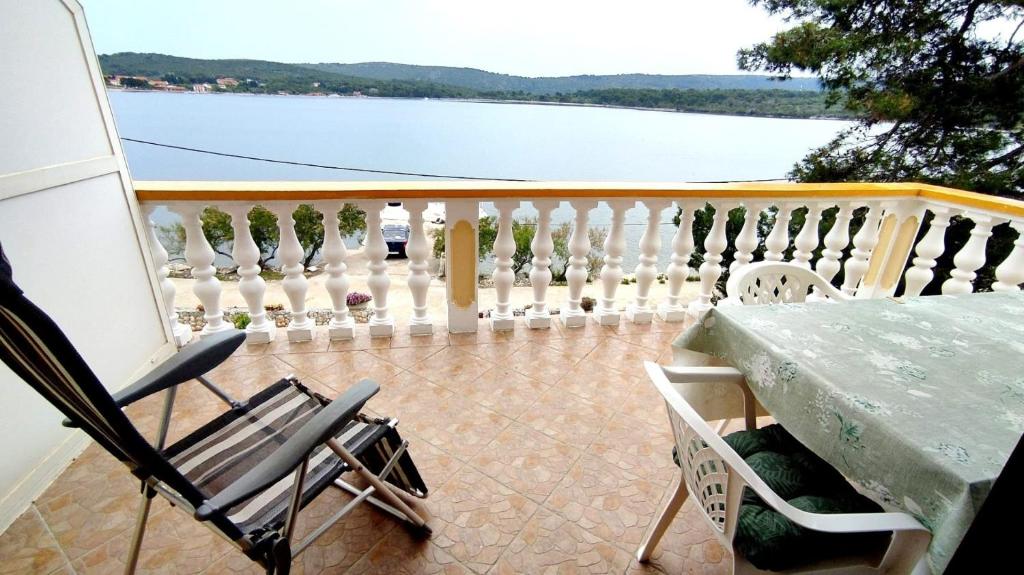 a balcony with a table and chairs and a view of the water at Apartments Josef - sea view in Veli Rat