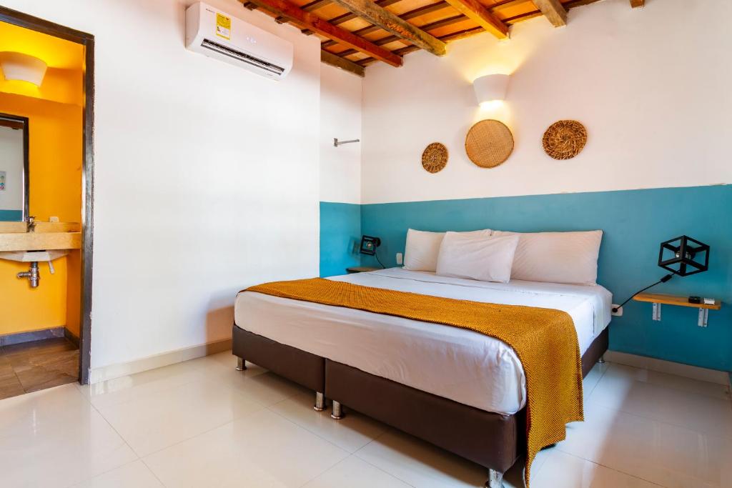 um quarto com uma cama com uma parede azul e branca em Gagaka Rua hostel em Santa Marta