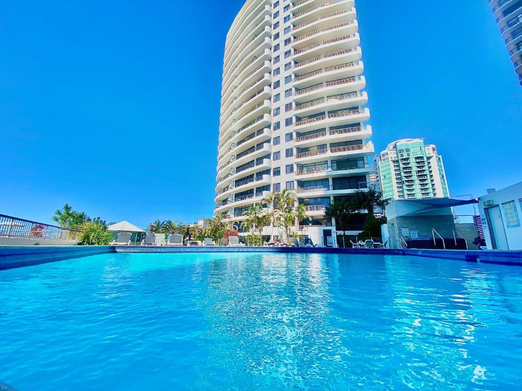 a large swimming pool in front of a tall building at Oceanfront Family Apartment Pool & BBQ in Gold Coast