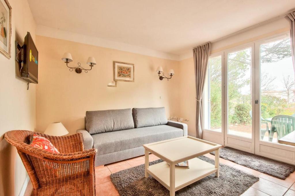 ein Wohnzimmer mit einem Sofa und einem Tisch in der Unterkunft Les maisons et villas de Pont Royal en Provence - maeva Home - Maison cosy et fe in Mallemort