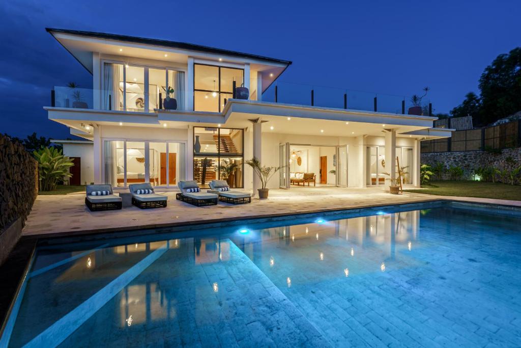 een huis met een zwembad voor een huis bij Villa Santosa Heights in Kuta Lombok