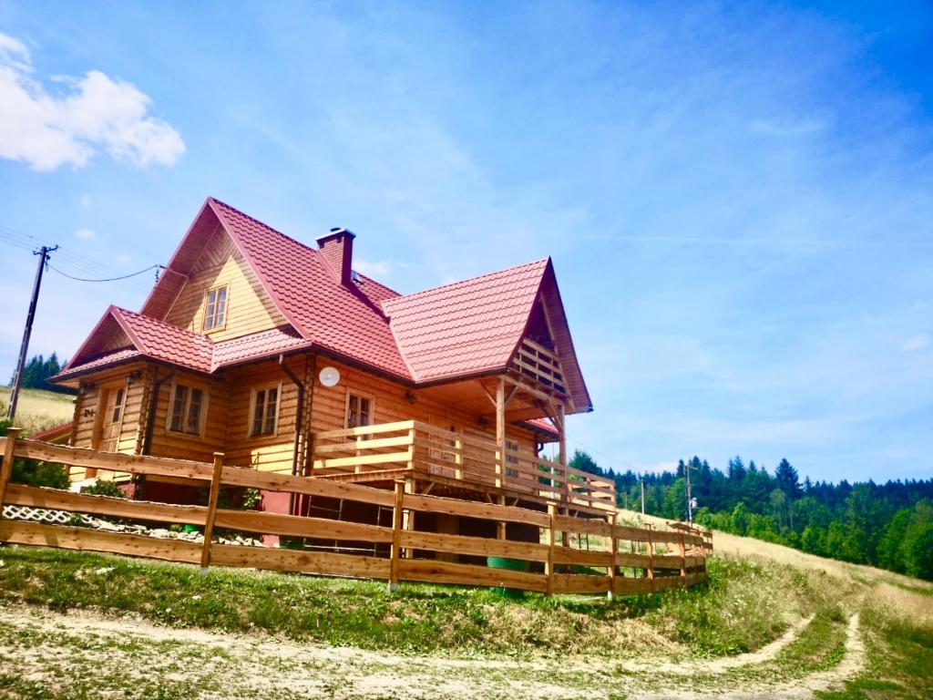 duży drewniany dom z czerwonym dachem w obiekcie Chata z widokiem na Babią Górę w mieście Pewel Wielka