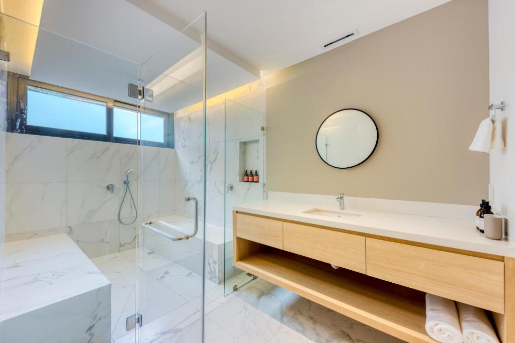 a bathroom with a shower and a sink and a mirror at Lumina at Cardinal San José del Cabo in San José del Cabo