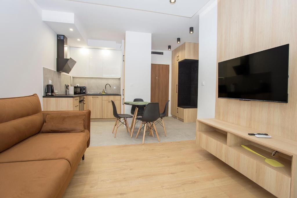 Il comprend un salon avec un canapé brun et une cuisine. dans l'établissement Urban Jungle apartament Emily, à Białystok