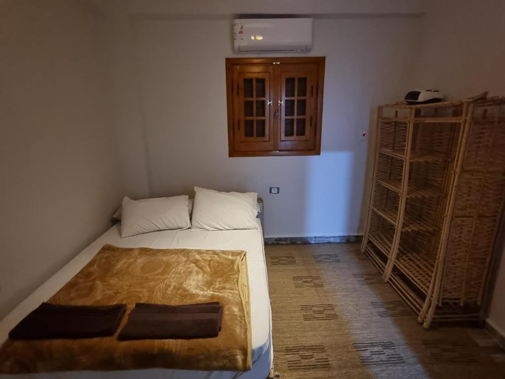 SEMIRAmis Siwa في سيوة: غرفة صغيرة بها سرير وبعض الرفوف