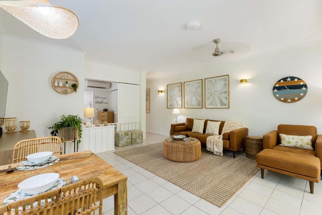 a living room with a couch and a table at Oasis Luxe on Macrossan Street - Stylish Residence in Port Douglas