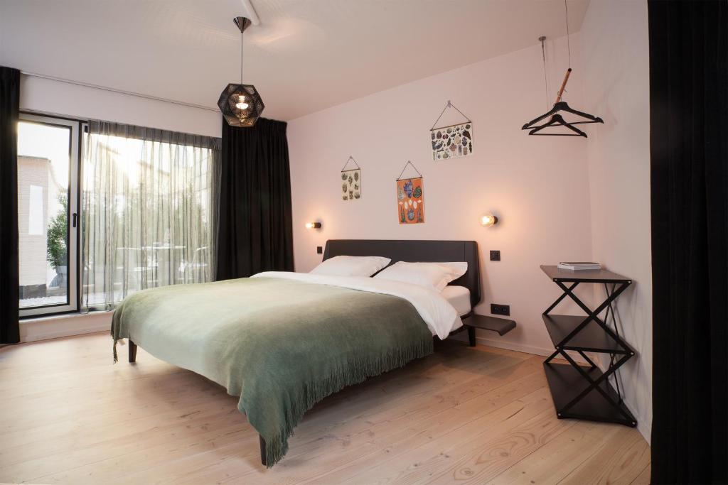 a bedroom with a large bed and a large window at B&B Lucy in the Sky in Antwerp