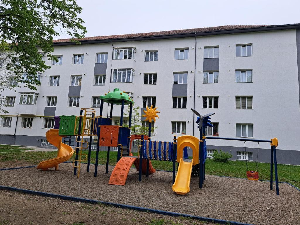 um parque infantil em frente a um grande edifício em Chic Studio em Onesti