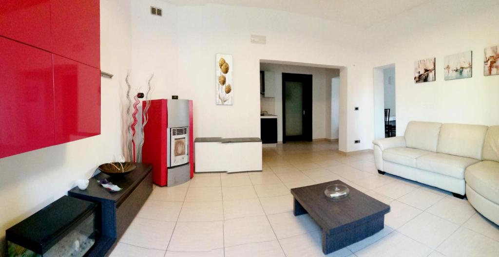 ein Wohnzimmer mit einem Sofa und einem roten Kühlschrank in der Unterkunft Heraclea Home in Roseto Capo Spulico