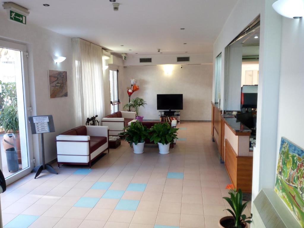 a living room with couches and a tv in it at Hotel San Nazario in Varazze