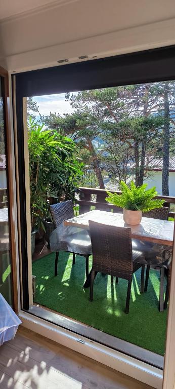 d'une terrasse avec une table et des chaises à l'extérieur de la fenêtre. dans l'établissement Nid douillet, à Gréolières