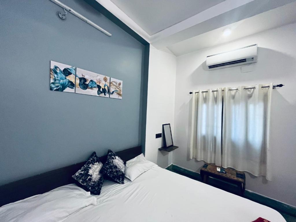 1 dormitorio con cama blanca y ventana en Ganga Guest House, en Varanasi