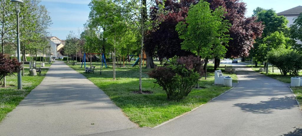 a path in a park with trees and benches at Apartman 222 in Brčko