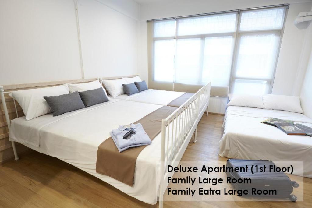 twee grote bedden in een kamer met ramen bij Platinum Deluxe Shopping Apartments in Bangkok