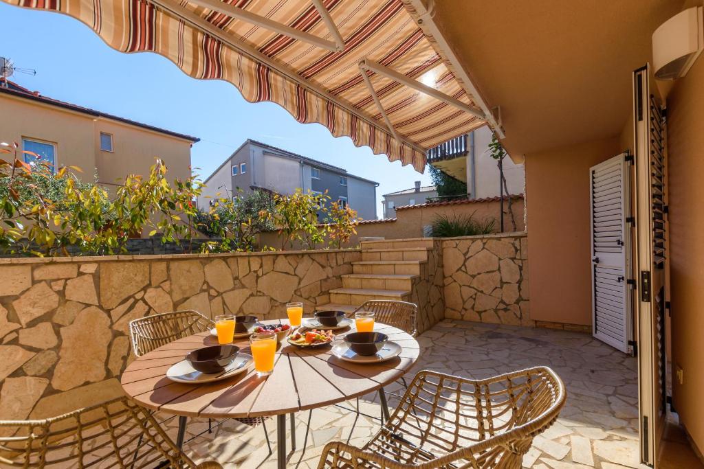 a patio with a table and chairs on a stone wall at Studio Apartment Mali in Medulin