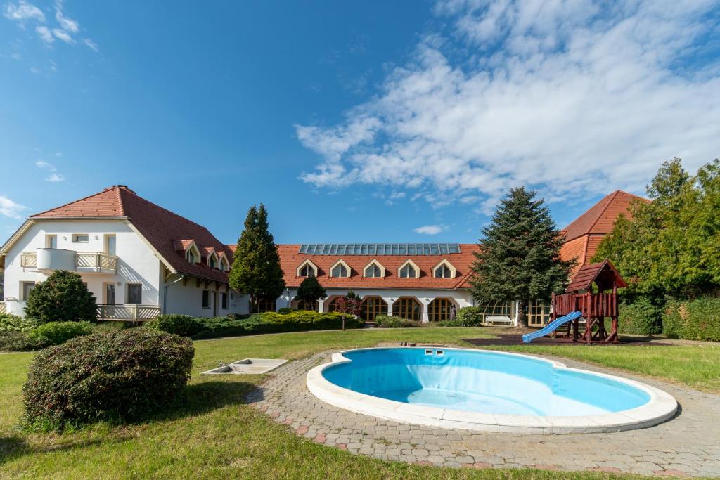 a house with a swimming pool in the yard at Global Apartmanház in Vonyarcvashegy
