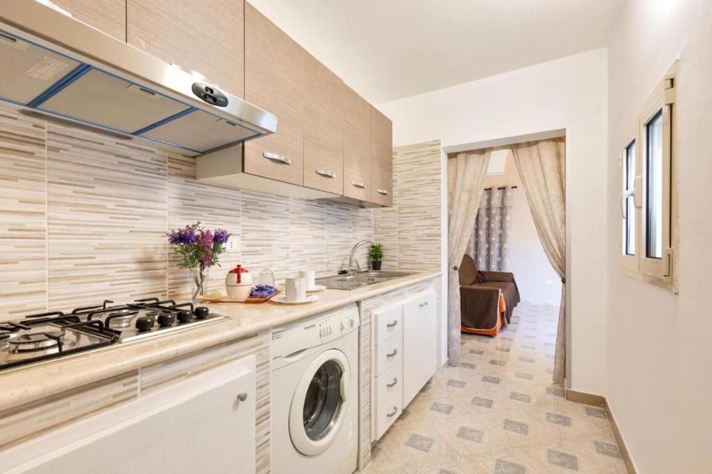uma cozinha com um lavatório e uma máquina de lavar roupa em La Casa di Anna em Sava