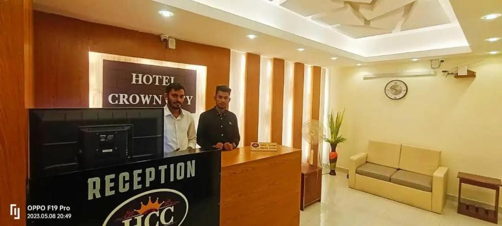two men standing at a reception desk in a room at Hotel Crown City in Chittagong