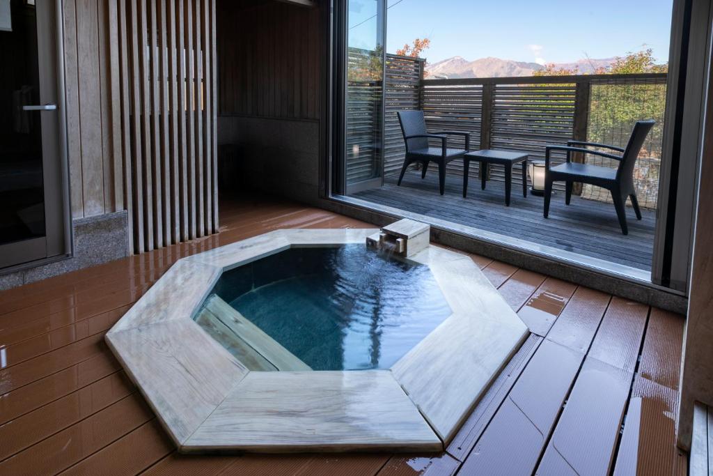 a pool in the middle of a patio with a table and chairs at Bettei Soan in Minami Aso