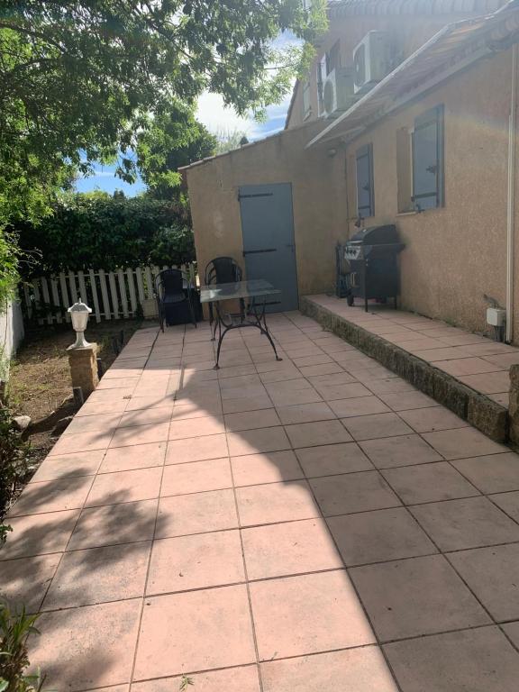 a patio with a table and chairs in front of a house at Maison Bouchou in Eyguières