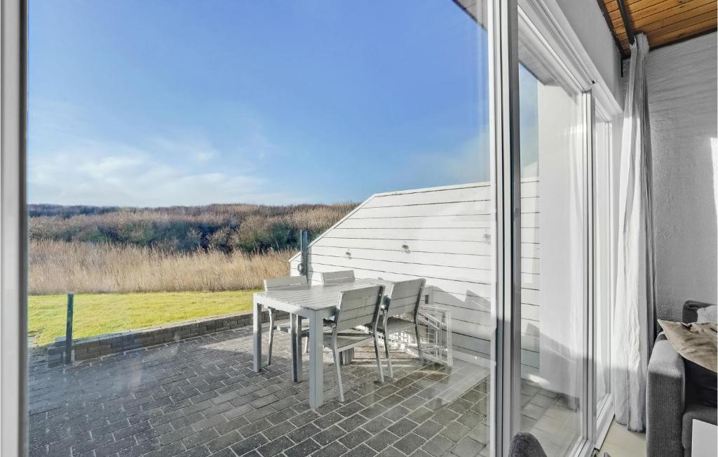 patio con mesa y sillas en el balcón en Cozy Apartment In Vestervig With Indoor Swimming Pool, en Vestervig