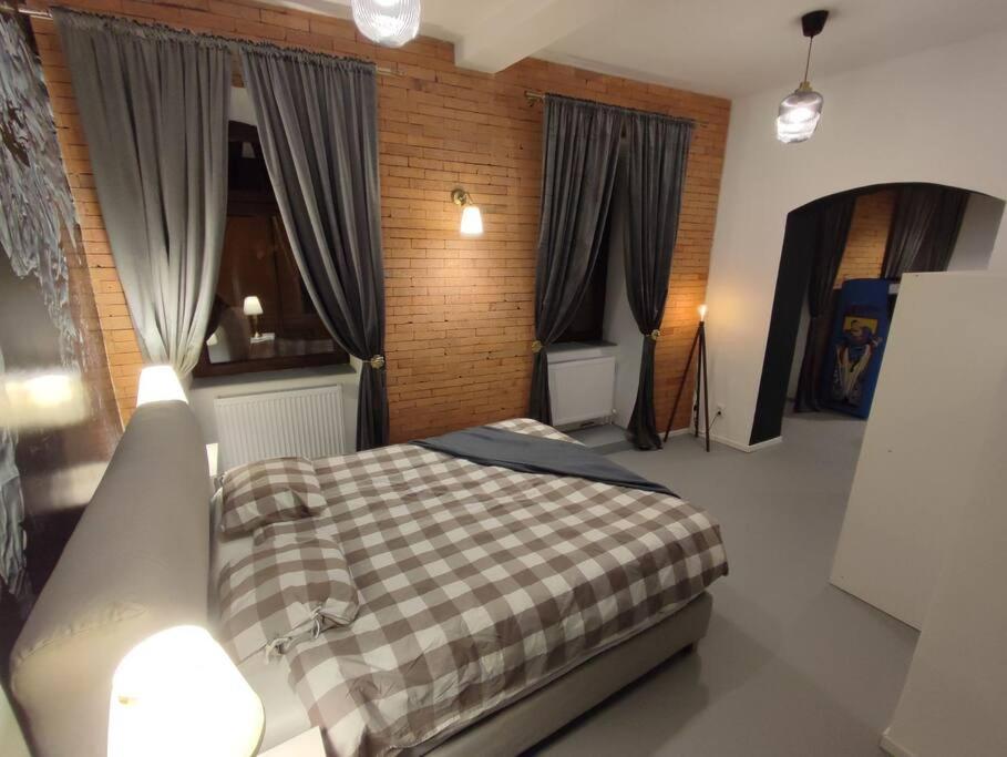 a bedroom with a bed with a checkered blanket at Arcade Apartament in Orăştie