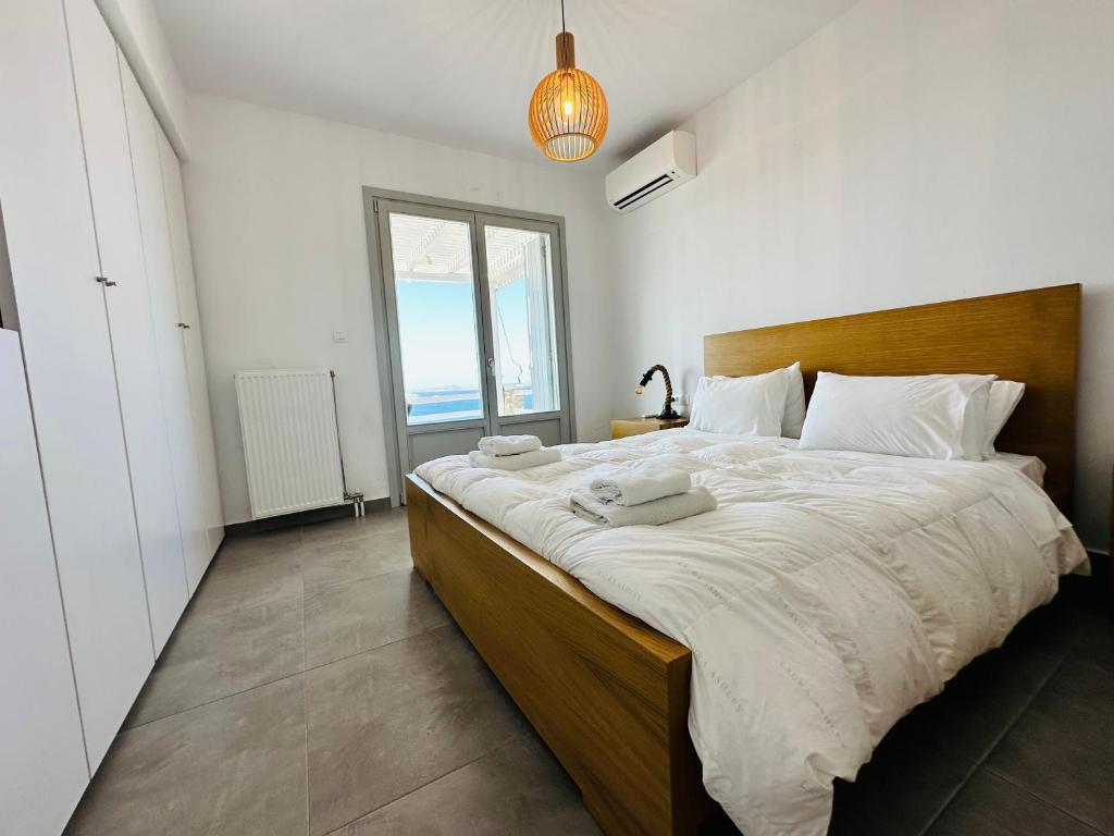 una camera con un grande letto e una grande finestra di Seaview & Jacuzzi summer residence a Mykonos Città