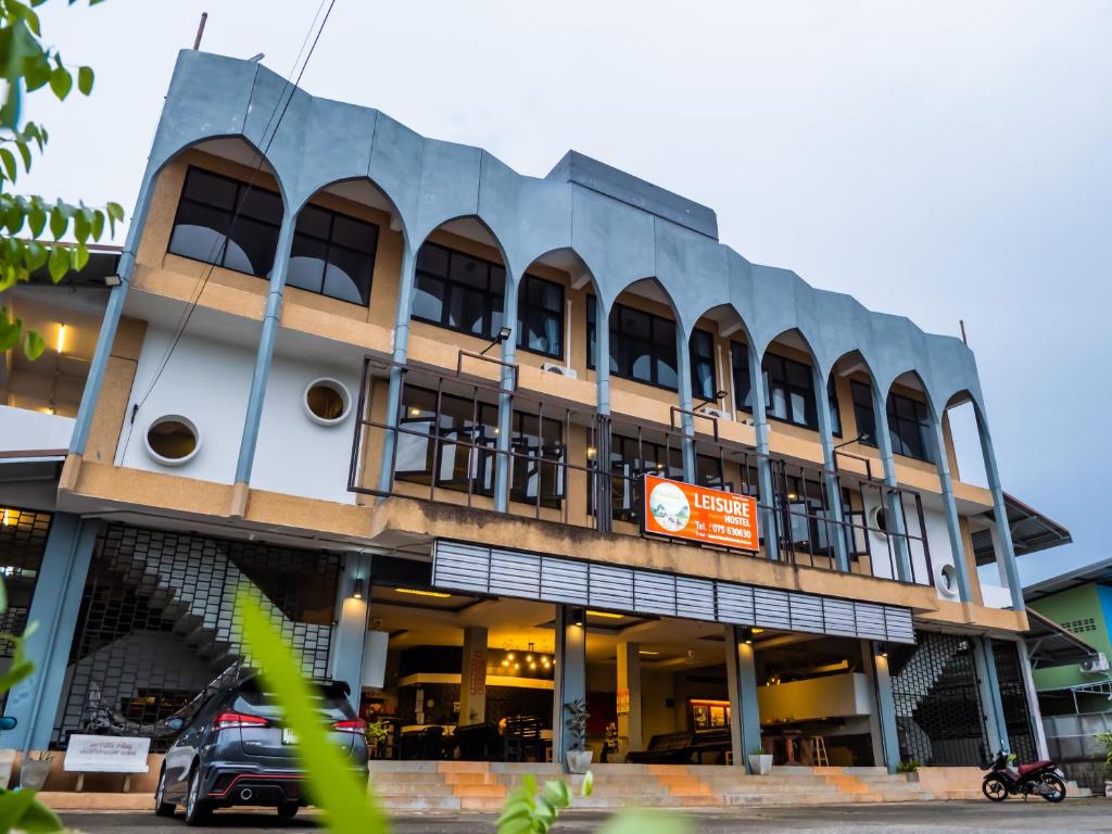 budynek z samochodem zaparkowanym przed nim w obiekcie Leisure Hostel w mieście Krabi