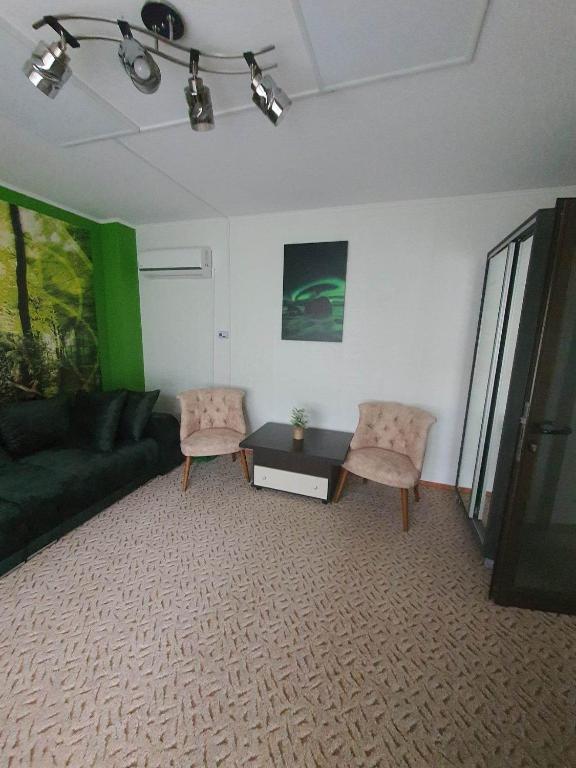 a living room with a couch and a table and chairs at Magic Home in Slănic