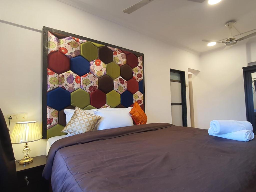 a bedroom with a large bed with a large headboard at OSI Apartments Perry Cross Bandra West in Mumbai
